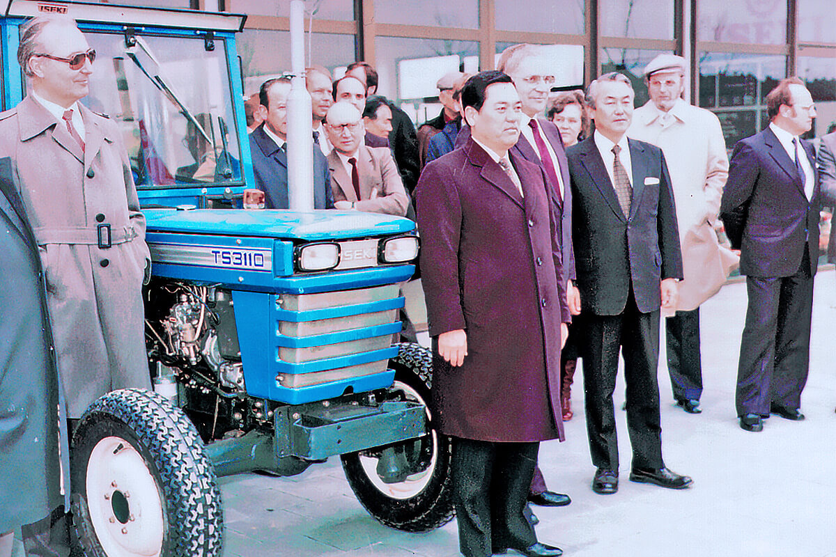 Japońscy i niemieccy przedsiębiorcy ISEKI stoją obok ciągnika